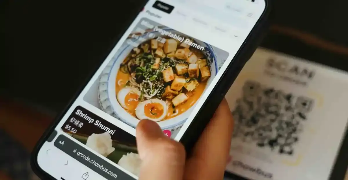 Customer using mobile QR ordering system to browse food menu in hotel restaurant