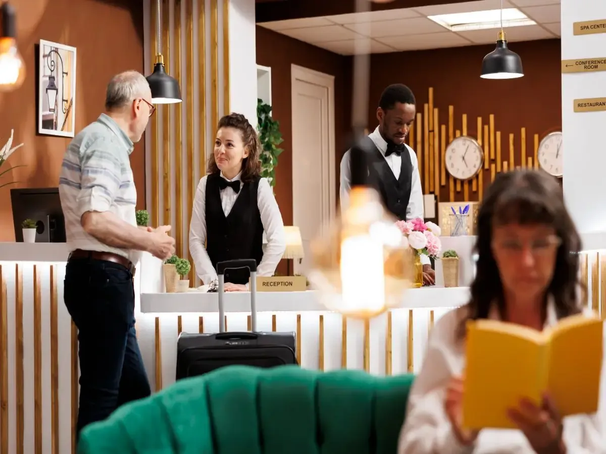 Hotel guest speaking with reception staff during hotel check-in at the front desk