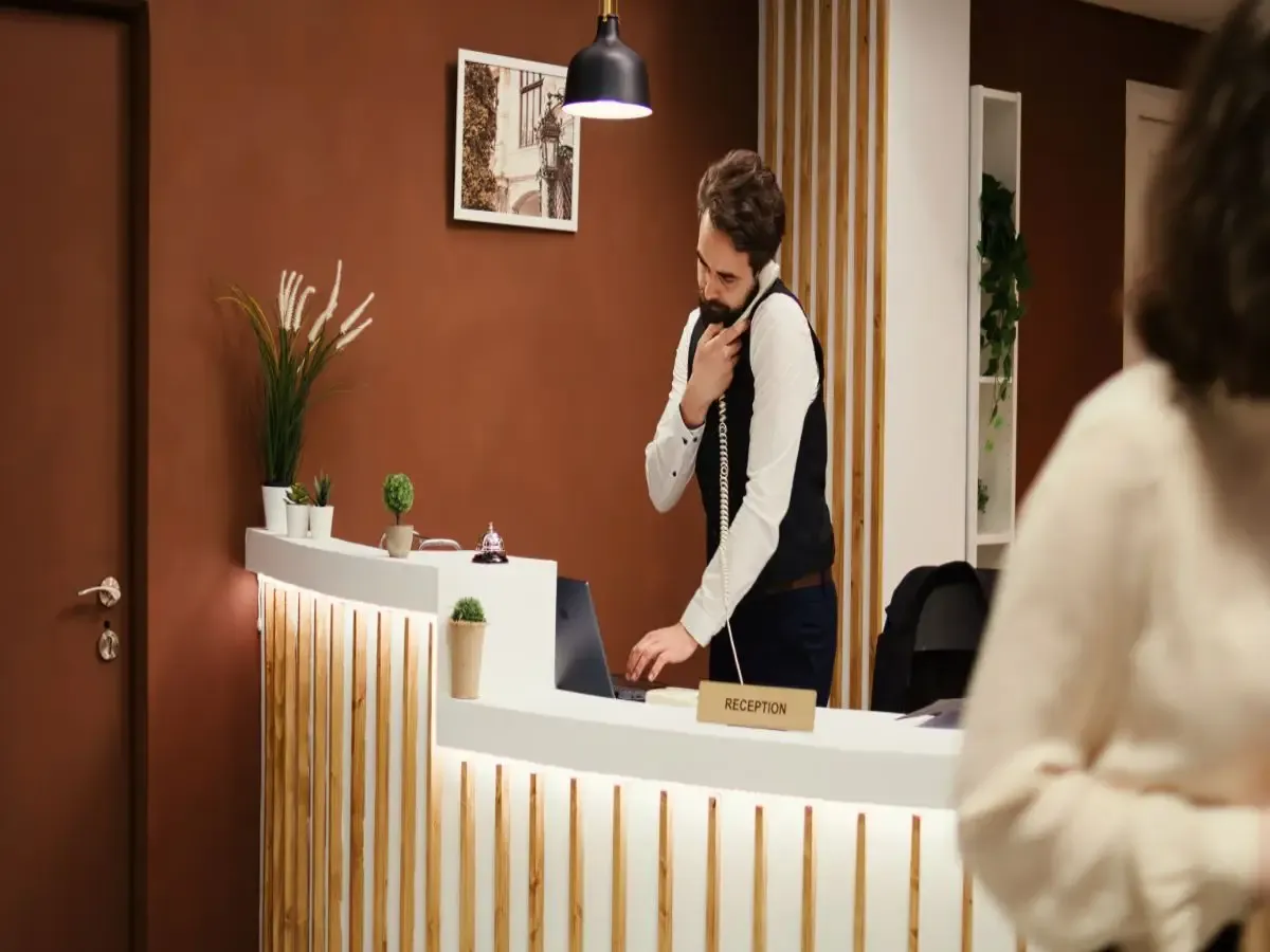 Hotel front desk employee handling guest inquiries to reduce front desk wait times during check-in