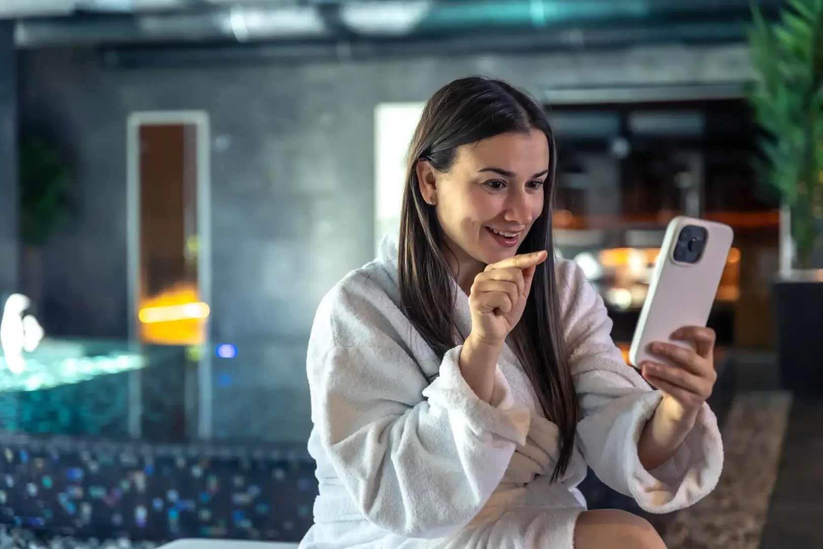 Hotel guest using an AI hotel chatbot on a smartphone to request services and get instant assistance during her stay