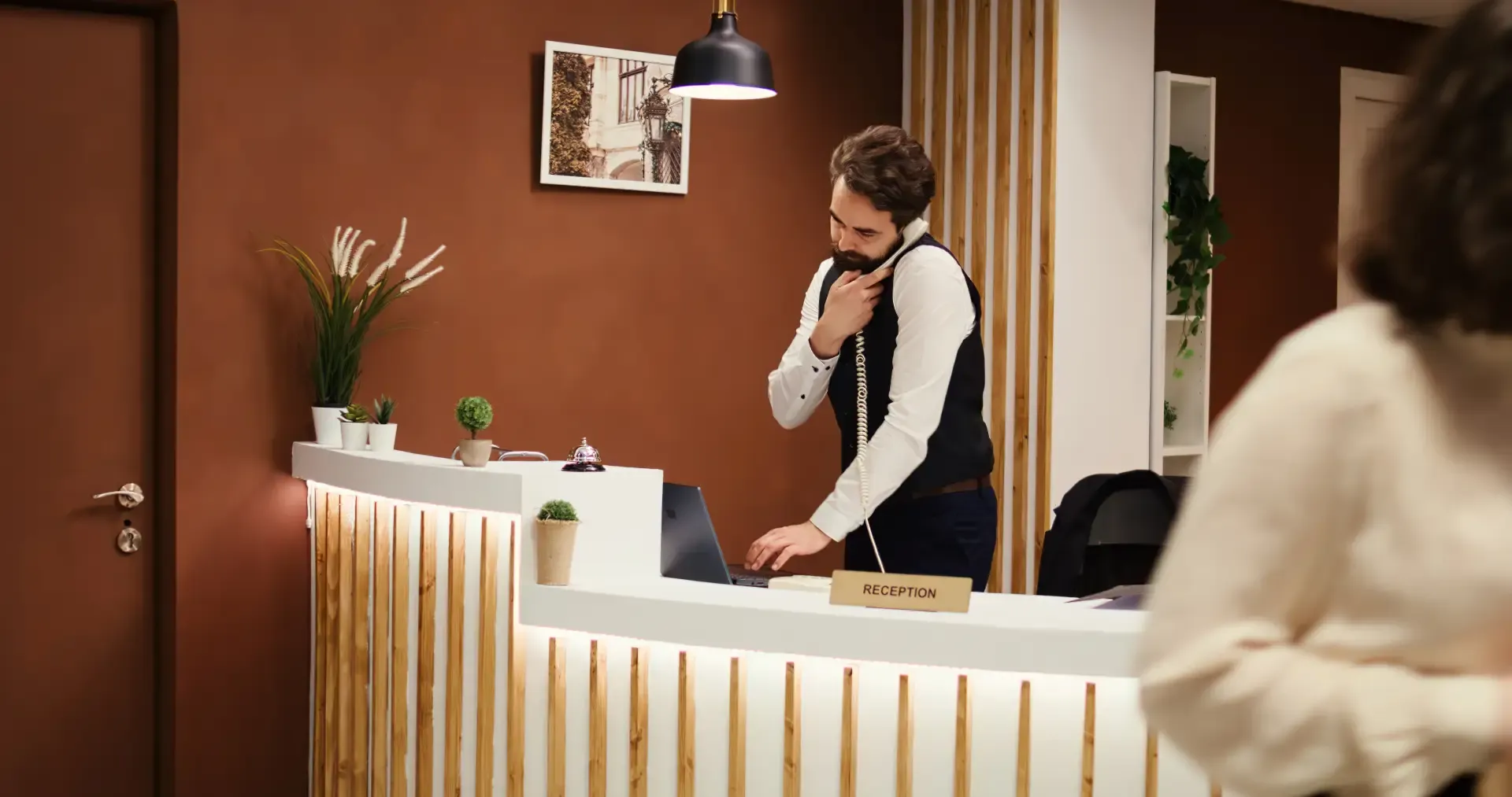 Hotel receptionist calling a guest to follow up on a no-show reservation and reduce booking cancellations